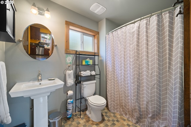 bathroom featuring sink, tile floors, and toilet