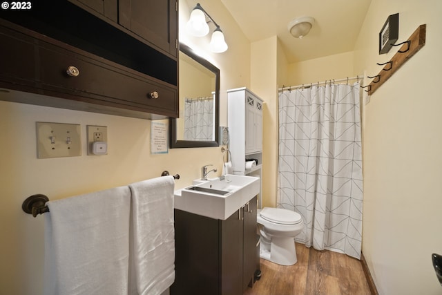 bathroom with wood-type flooring, toilet, and large vanity