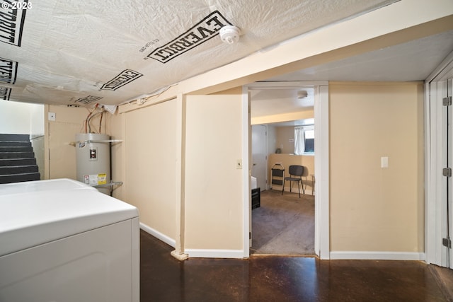 basement featuring water heater and dark carpet