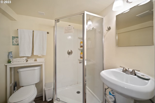 bathroom with sink, walk in shower, and toilet