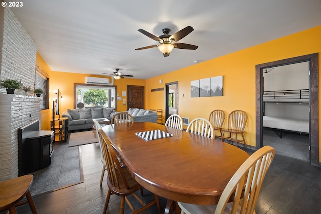 dining room with an AC wall unit, dark hardwood / wood-style flooring, ceiling fan, and a fireplace