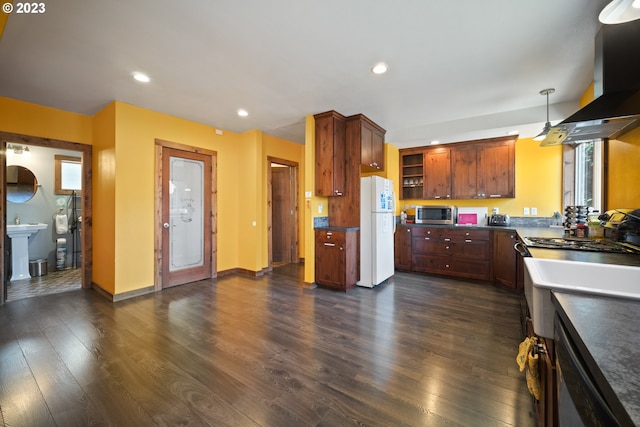 kitchen featuring white fridge, decorative light fixtures, dark hardwood / wood-style flooring, a healthy amount of sunlight, and island range hood