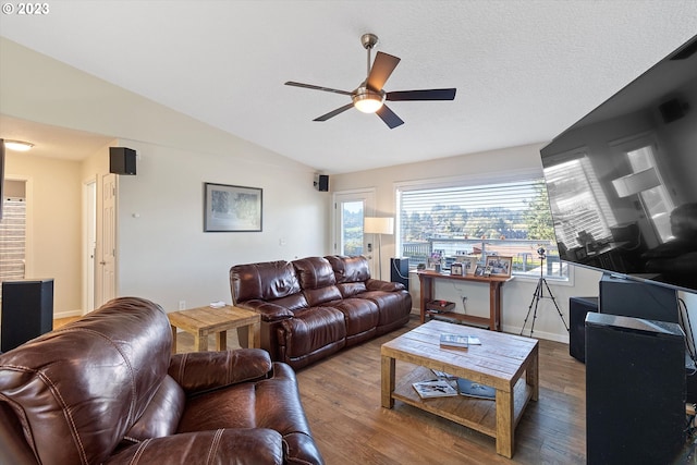 living room with ceiling fan, hardwood / wood-style floors, and vaulted ceiling