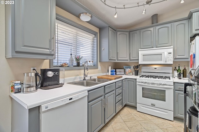 kitchen with white appliances, gray cabinets, light tile patterned floors, and sink