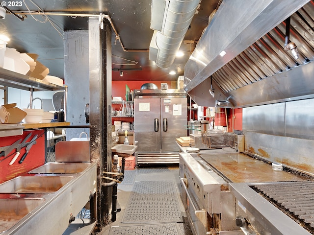 interior space featuring island range hood, stainless steel counters, and high end refrigerator