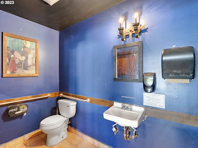 bathroom featuring toilet, tile floors, and sink