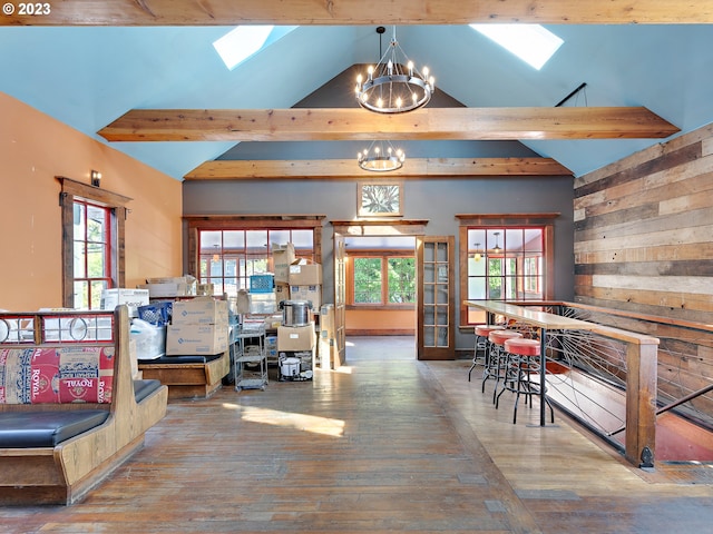 interior space featuring beamed ceiling, hardwood / wood-style flooring, and a skylight