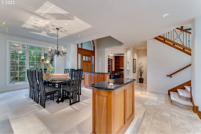 kitchen with a kitchen island, hanging light fixtures, a notable chandelier, and light tile floors