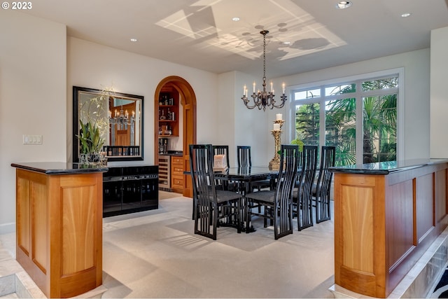 carpeted dining space featuring an inviting chandelier and wine cooler