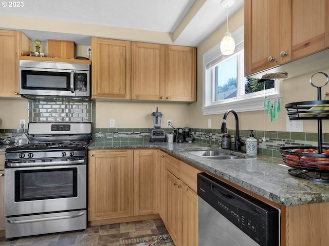 kitchen featuring decorative light fixtures, sink, stainless steel appliances, dark stone counters, and tasteful backsplash