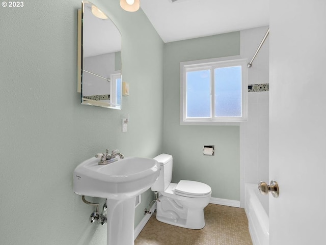 bathroom with toilet, tile floors, and tiled shower / bath combo