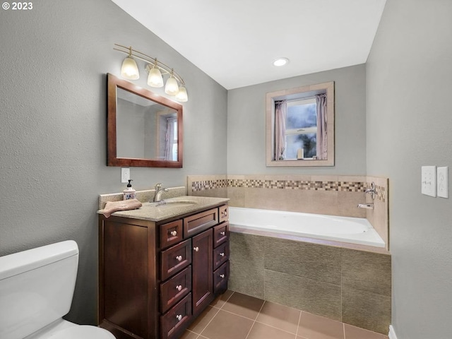 bathroom with toilet, a relaxing tiled bath, tile flooring, and vanity