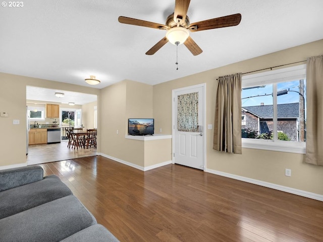 living room featuring ceiling fan, dark wood-type flooring, and sink