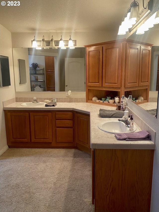 bathroom with a textured ceiling and dual vanity