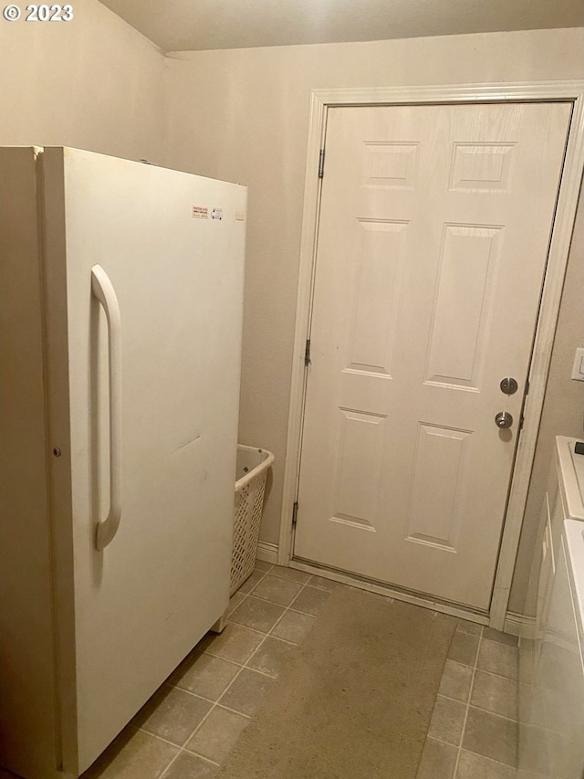 kitchen with white fridge and light tile floors