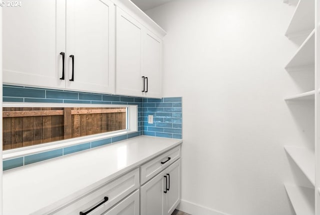 kitchen featuring tasteful backsplash and white cabinetry