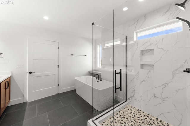 bathroom featuring tile patterned flooring, independent shower and bath, and vanity