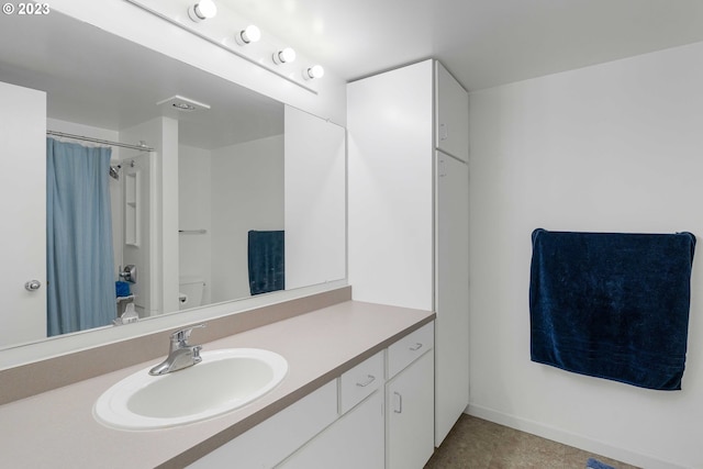 bathroom with vanity, tile floors, and toilet