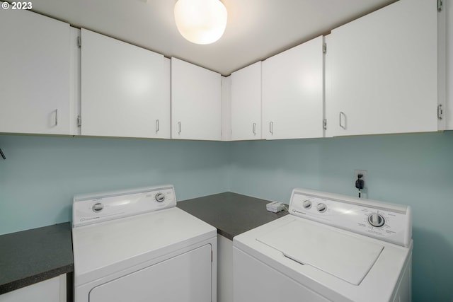 clothes washing area featuring washer and clothes dryer and cabinets