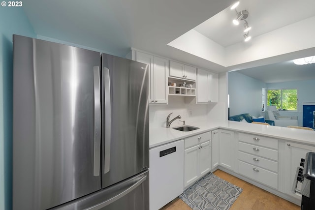 kitchen featuring light hardwood / wood-style floors, white cabinetry, stainless steel fridge, sink, and white dishwasher