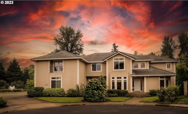 view of front of property with a yard and a balcony