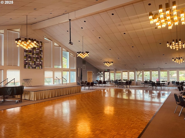 interior space with a wealth of natural light, a notable chandelier, and high vaulted ceiling