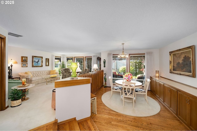 kitchen featuring brown cabinetry, open floor plan, light wood-style flooring, and decorative light fixtures