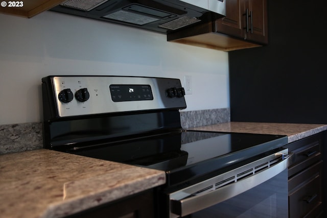 kitchen with extractor fan, light countertops, dark brown cabinetry, and stainless steel electric stove