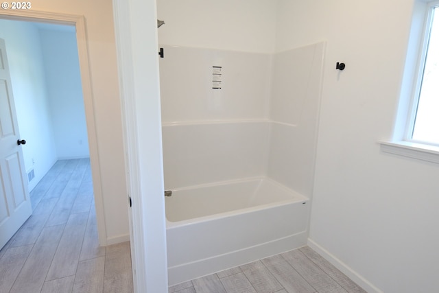 full bathroom featuring wood tiled floor, baseboards, and shower / washtub combination