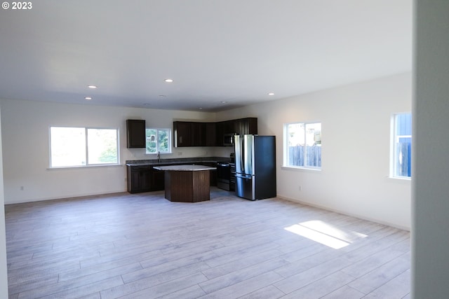 kitchen featuring recessed lighting, light wood-style floors, freestanding refrigerator, open floor plan, and a kitchen island