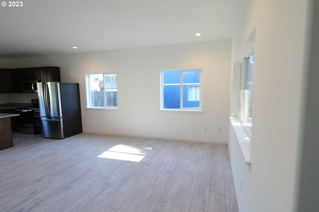 kitchen featuring light wood finished floors, appliances with stainless steel finishes, open floor plan, and recessed lighting