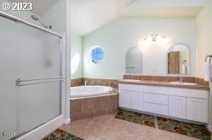 bathroom with tile patterned floors, vaulted ceiling, separate shower and tub, and vanity