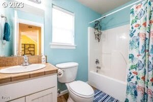 full bathroom with toilet, vanity, and shower / bath combo