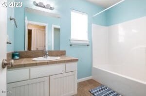 bathroom with vanity and washtub / shower combination