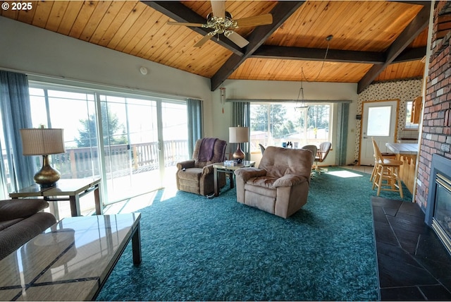 living area with a brick fireplace, dark colored carpet, lofted ceiling with beams, wood ceiling, and a ceiling fan