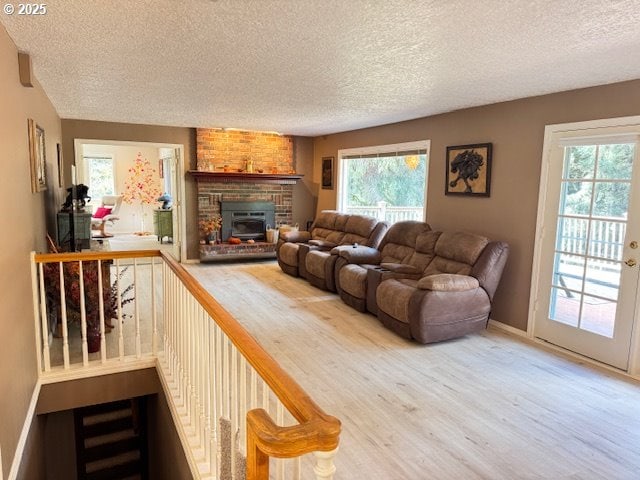 living area featuring a textured ceiling, baseboards, and wood finished floors