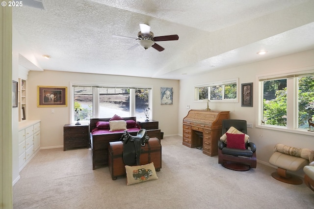 living room with a wealth of natural light, light carpet, and a textured ceiling