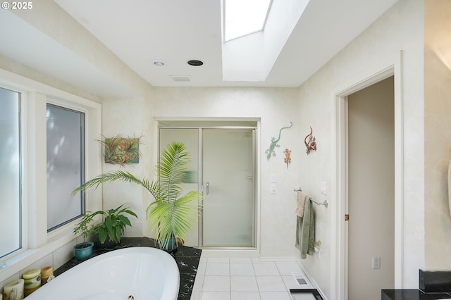 bathroom featuring a skylight, a shower stall, a whirlpool tub, and tile patterned floors