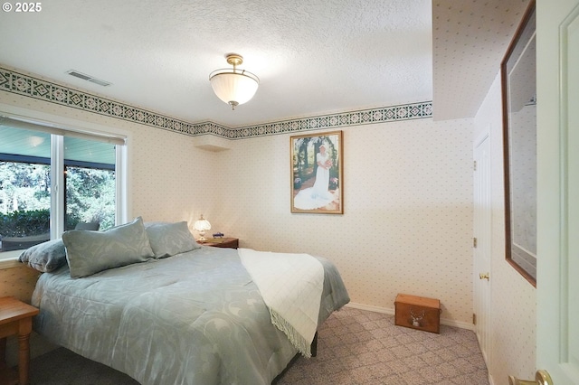 carpeted bedroom with visible vents, a textured ceiling, baseboards, and wallpapered walls