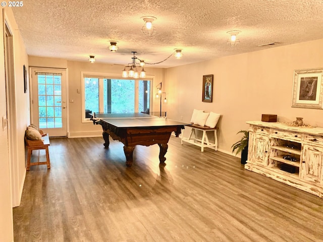 playroom featuring a textured ceiling, pool table, wood finished floors, and baseboards