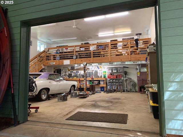 garage with a ceiling fan and wooden walls