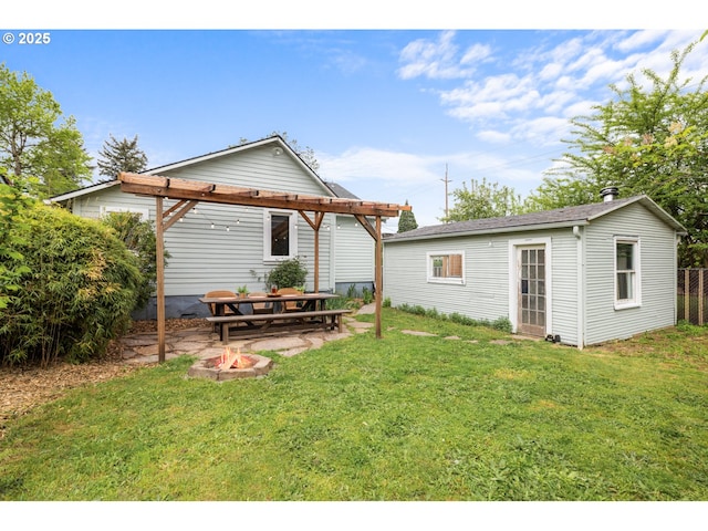 rear view of house with a lawn, an outbuilding, a patio area, fence, and a pergola