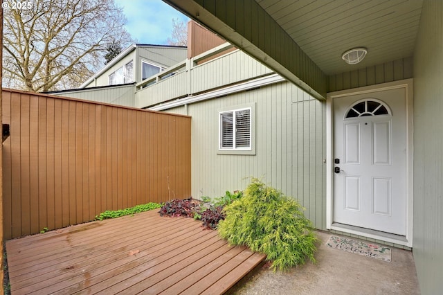 property entrance featuring fence and a wooden deck