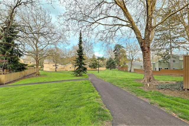 view of home's community with a residential view, fence, and a lawn