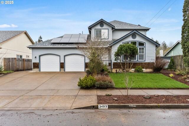 view of property with a garage, a front yard, and solar panels