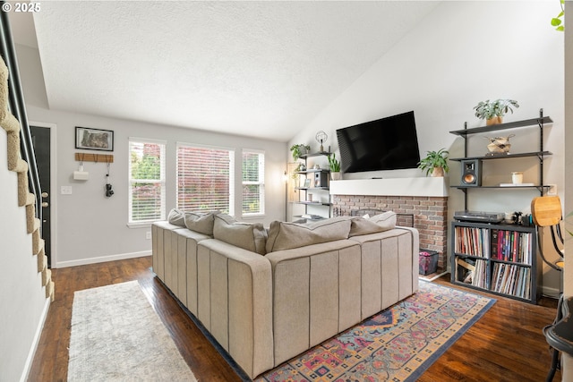 16190 SW Theresa Ct, Beaverton, OR 97007 - living room featuring a fireplace, a textured ceiling, dark wood-type flooring, vaulted ceiling, and baseboards