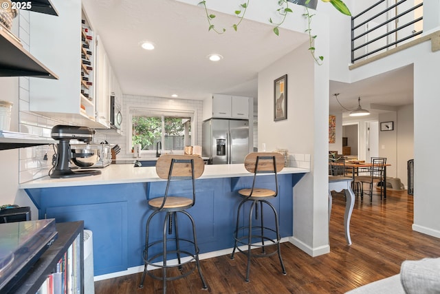 16190 SW Theresa Ct, Beaverton, OR 97007 - kitchen with appliances with stainless steel finishes, dark wood-style floors, decorative backsplash, a peninsula, and recessed lighting