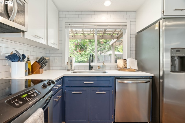 16190 SW Theresa Ct, Beaverton, OR 97007 - kitchen featuring stainless steel appliances, a sink, blue cabinets, tasteful backsplash, and light countertops