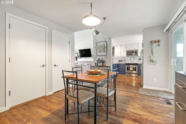 16190 SW Theresa Ct, Beaverton, OR 97007 - dining room featuring dark wood-style floors, baseboards, and a textured ceiling