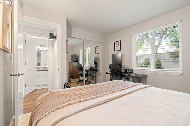 16190 SW Theresa Ct, Beaverton, OR 97007 - bedroom featuring wood finished floors, a closet, a desk, and ensuite bathroom